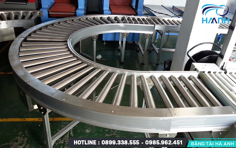 Băng tải con lăn cong là một hệ thống băng tải được thiết kế với hình dạng cong, giúp vận chuyển hàng hóa theo các góc cua