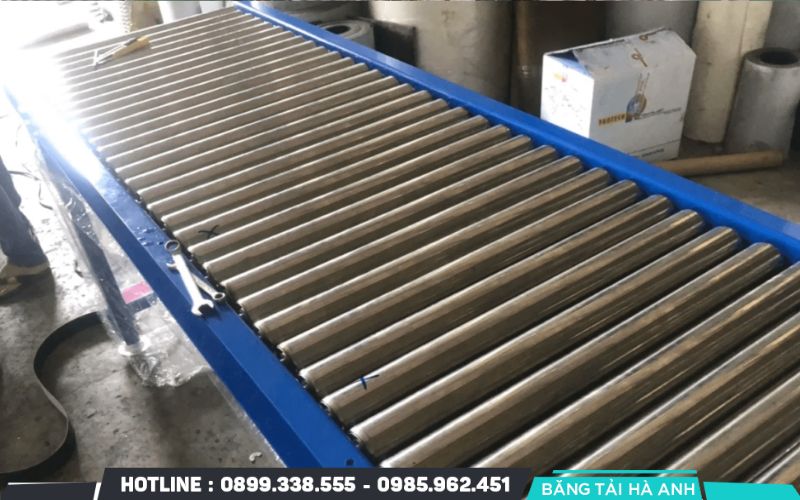 Băng tải con lăn thép hoạt động dựa trên chuyển động quay của các con lăn, giúp hàng hóa di chuyển theo hướng mong muốn