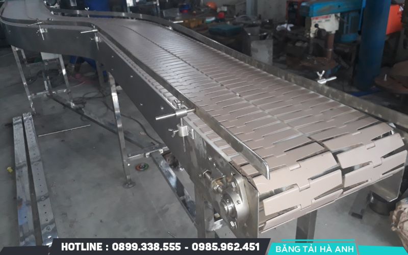 Băng tải xích vận hành dựa trên sức kéo của các mắt xích để vận chuyển những kiện hàng nặng