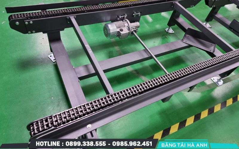 Băng tải xích là hệ thống vận chuyển sử dụng các mắt xích liên kết với nhau để kéo hàng hóa đi theo một lộ trình cố định