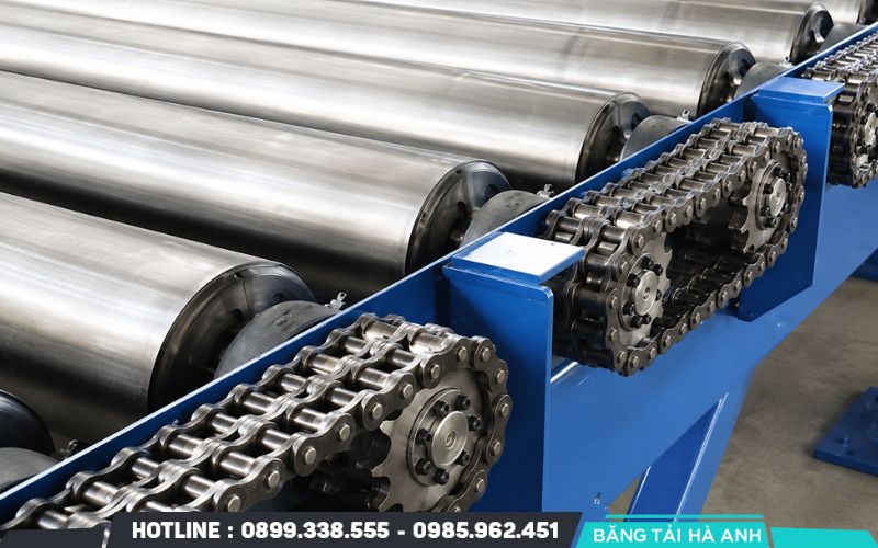 Băng tải con lăn truyền động xích sử dụng hệ thống nhông và xích để truyền lực từ motor đến các con lăn
